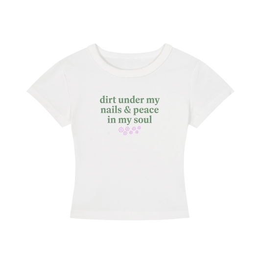White t-shirt with green text 'dirt under my nails & peace in my soul' on a white background