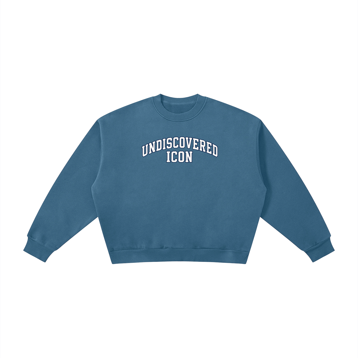 A dusty blue cropped crewneck sweatshirt with 'UNDISCOVERED ICON' printed in white arched block letters across the chest, displayed flat against a solid white background.