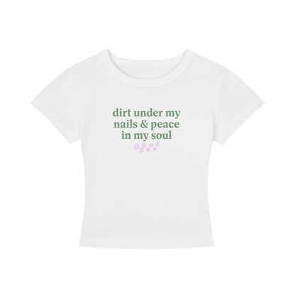 White t-shirt with green text 'dirt under my nails & peace in my soul' on a white background